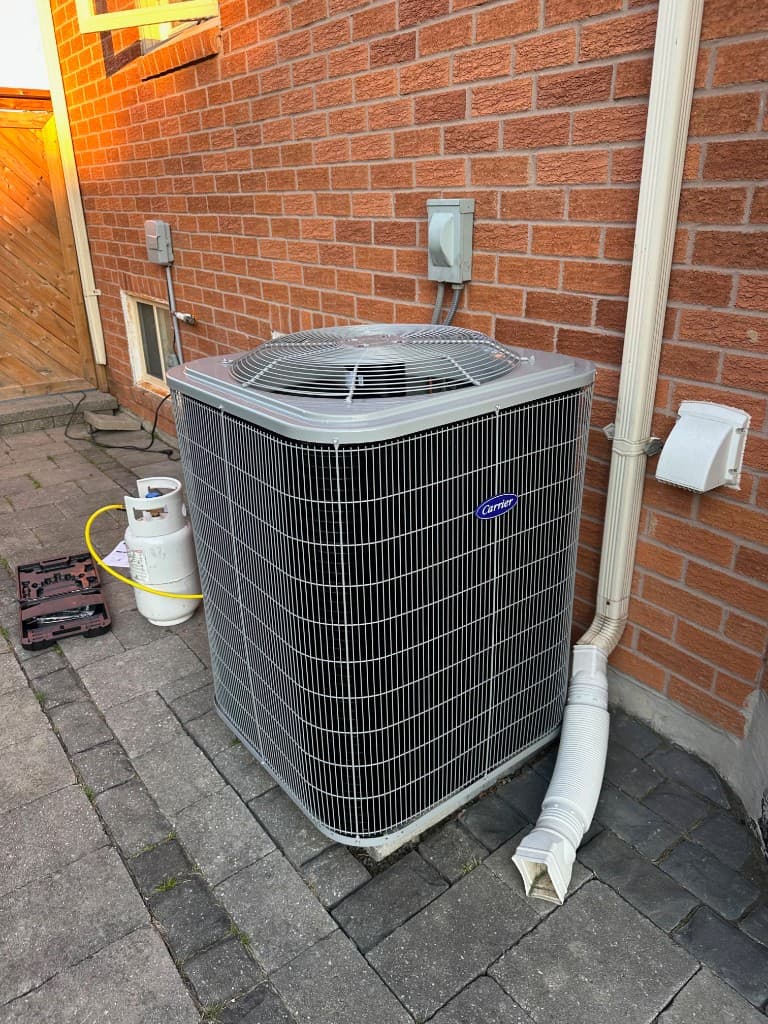 Carrier air conditioner installed beside a brick house